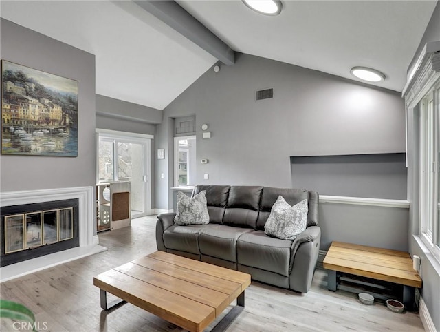 25081 Leucadia St Unit F, Laguna Niguel, CA 92677 - living room with beamed ceiling, light wood-type flooring, high vaulted ceiling, baseboards, and a glass covered fireplace