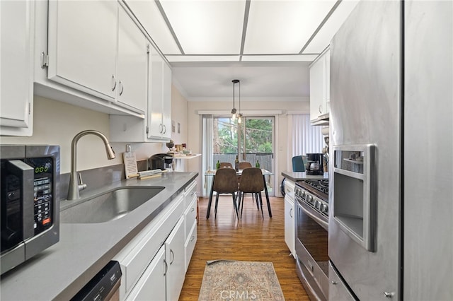 985 S Idaho St Unit 46, La Habra, CA 90631 - kitchen with stainless steel appliances, a sink, dark wood-style flooring, white cabinets, and ornamental molding