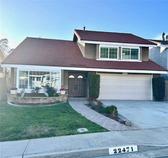 view of front facade featuring a garage, stucco siding, driveway, and a front yard