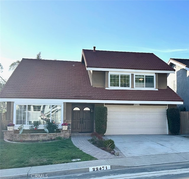 view of front of house featuring a garage, a front lawn, and driveway