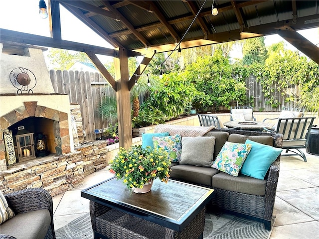 view of patio with a gazebo, fence, and an outdoor living space with a fireplace