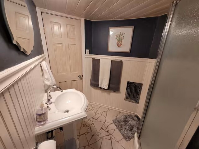810 Lake Dr, Lake Arrowhead, CA 92352 - bathroom with a decorative wall, wood ceiling, a shower with door, a sink, and wainscoting