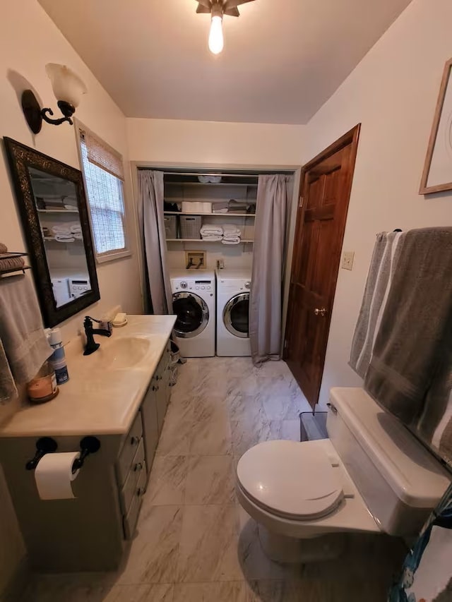 810 Lake Dr, Lake Arrowhead, CA 92352 - bathroom featuring washing machine and clothes dryer, toilet, marble look tile flooring, and vanity