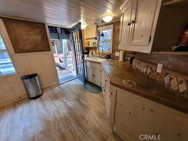 810 Lake Dr, Lake Arrowhead, CA 92352 - kitchen featuring tile countertops, wood ceiling, plenty of natural light, wainscoting, and wooden walls
