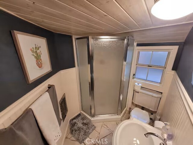 810 Lake Dr, Lake Arrowhead, CA 92352 - bathroom featuring a shower stall, a sink, wood ceiling, toilet, and wainscoting