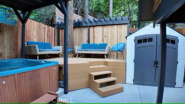 810 Lake Dr, Lake Arrowhead, CA 92352 - view of patio / terrace featuring a hot tub, fence, a storage unit, and an outbuilding