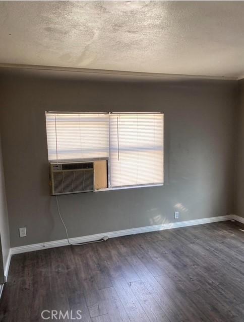 2404 E California, Bakersfield, CA 93307 - empty room featuring dark wood-style floors, baseboards, and a textured ceiling