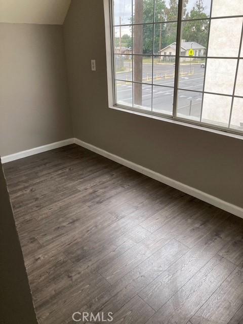 2404 E California, Bakersfield, CA 93307 - additional living space featuring dark wood-type flooring, lofted ceiling, and baseboards