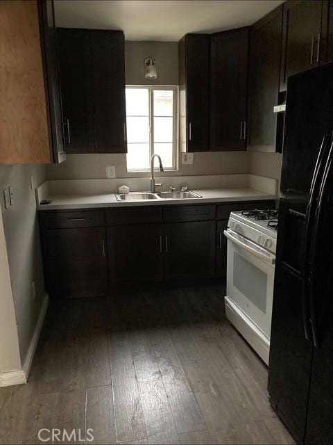 2404 E California, Bakersfield, CA 93307 - kitchen featuring black refrigerator with ice dispenser, white range with gas cooktop, a sink, light wood-type flooring, and light countertops