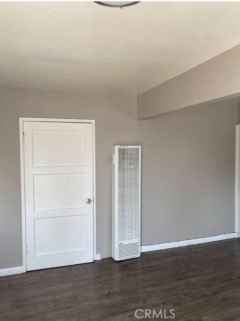 2404 E California, Bakersfield, CA 93307 - unfurnished room featuring a heating unit, baseboards, and dark wood-style flooring