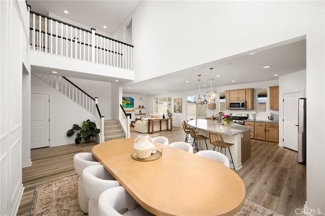 31768 Constellation Dr, Menifee, CA 92586 - dining room with light wood-type flooring, stairway, recessed lighting, and a high ceiling