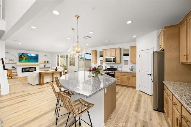 31768 Constellation Dr, Menifee, CA 92586 - kitchen with stainless steel appliances, light wood-style floors, a center island, a kitchen breakfast bar, and light stone counters