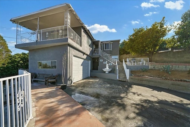 1745 College View Pl, Los Angeles, CA 90041 - view of side of property featuring a garage, stucco siding, concrete driveway, and a balcony