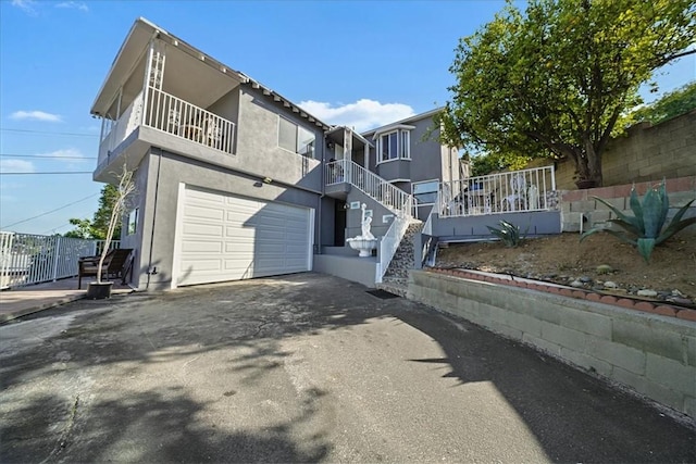 1745 College View Pl, Los Angeles, CA 90041 - view of front facade featuring stucco siding, an attached garage, fence, and aphalt driveway