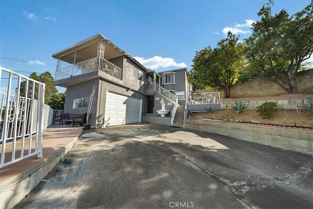 1745 College View Pl, Los Angeles, CA 90041 - exterior space featuring a garage, stucco siding, driveway, and a balcony