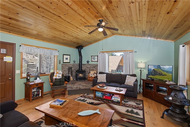 living area with light wood-type flooring, a wood stove, ceiling fan, and lofted ceiling