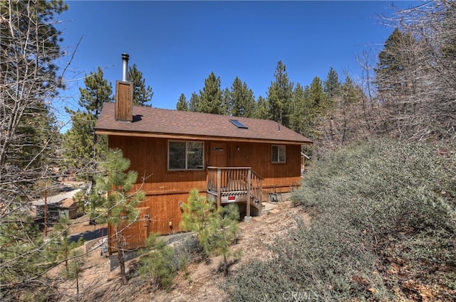 view of front of house featuring roof with shingles and a chimney