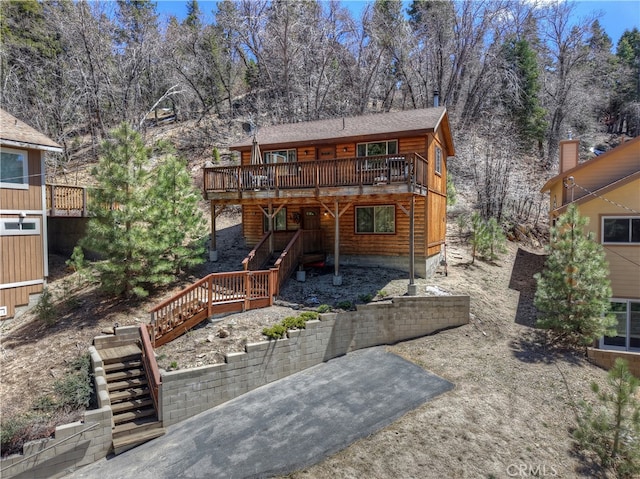 back of house featuring a patio area, a wooden deck, and stairway