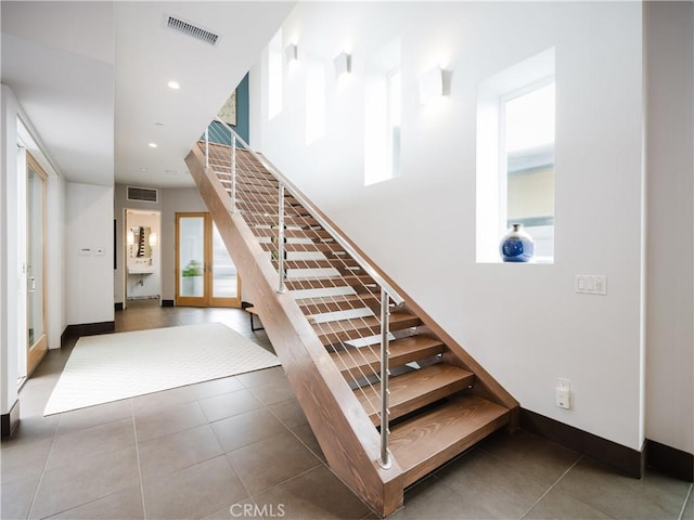 staircase featuring tile patterned flooring, visible vents, and recessed lighting