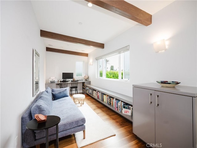 living room with beam ceiling and wood finished floors
