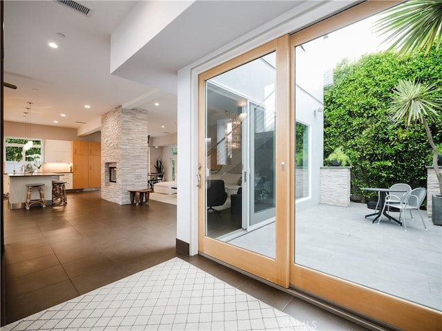 entryway featuring a fireplace, dark tile patterned flooring, visible vents, and recessed lighting