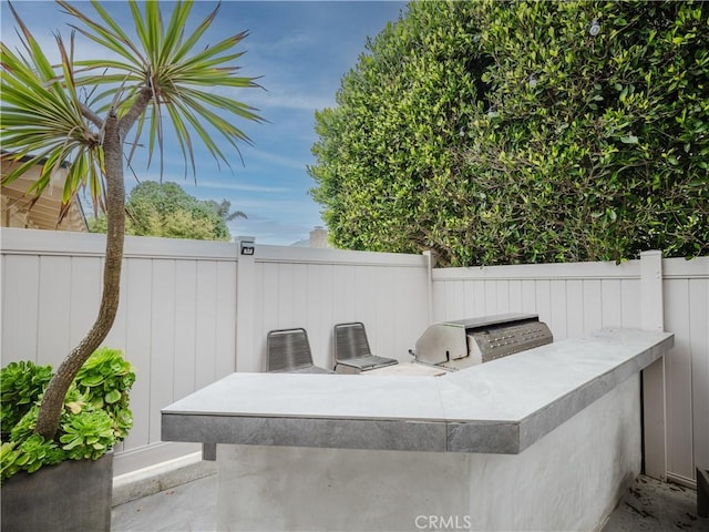 view of patio featuring fence and area for grilling