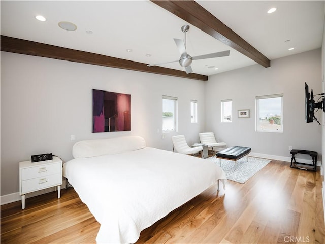 bedroom with baseboards, light wood-style floors, and beam ceiling