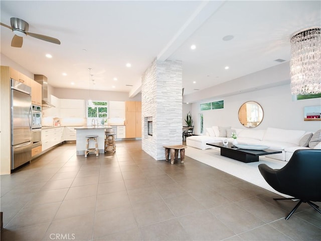 living room with a ceiling fan, light tile patterned flooring, and recessed lighting
