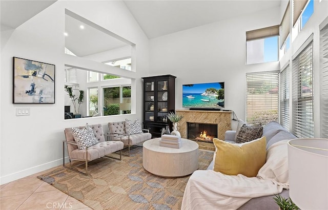 tiled living room featuring baseboards, a premium fireplace, and high vaulted ceiling