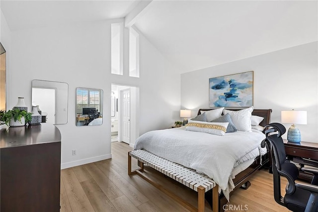 bedroom with baseboards, light wood-style flooring, high vaulted ceiling, and beamed ceiling