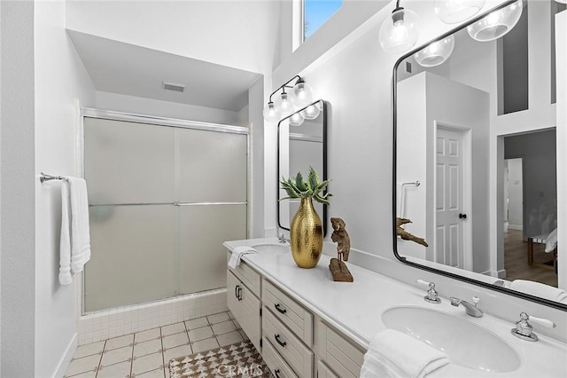 full bath with a sink, double vanity, tile patterned floors, a shower stall, and visible vents