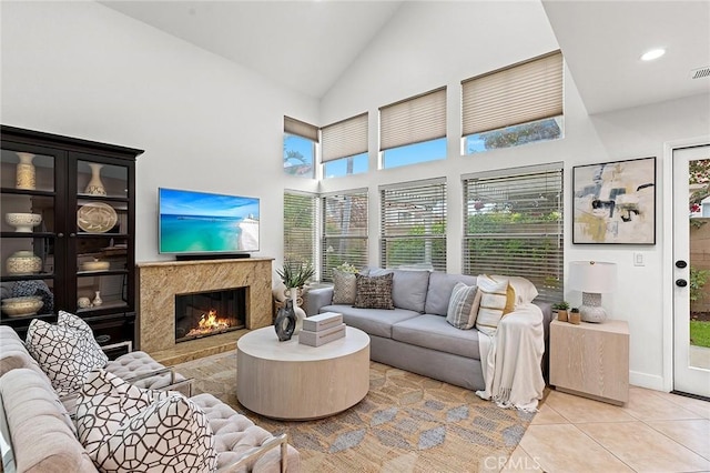 living room with high vaulted ceiling, visible vents, light tile patterned floors, and a fireplace