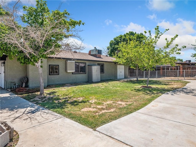 ranch-style home with stucco siding, fence, and a front yard