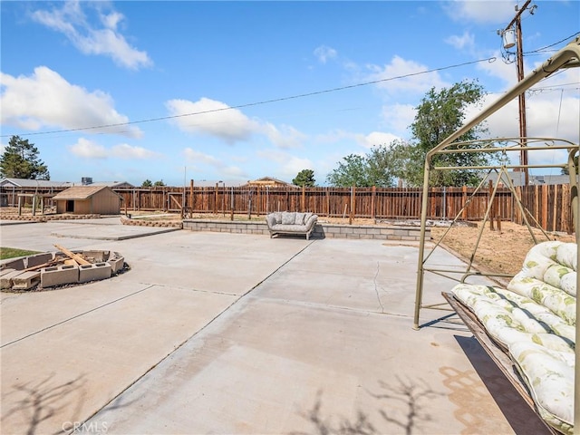 view of patio featuring a fenced backyard, an outdoor structure, an outdoor living space, and a storage shed