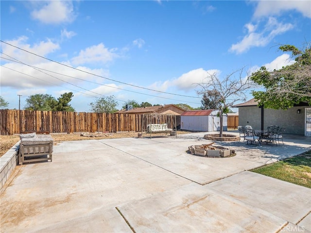 view of patio / terrace with a storage unit, an outdoor structure, and fence