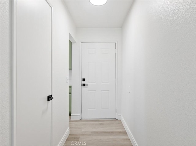 entryway featuring baseboards and light wood finished floors