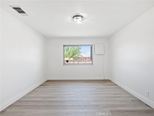 empty room featuring visible vents, baseboards, and light wood-style floors