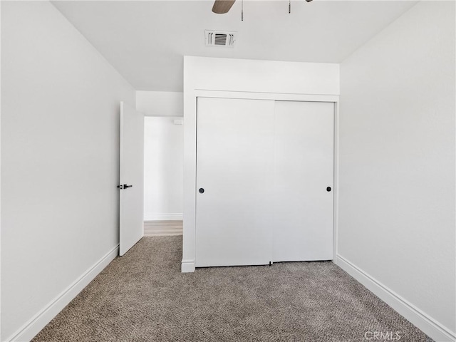 unfurnished bedroom with carpet floors, baseboards, visible vents, and a closet