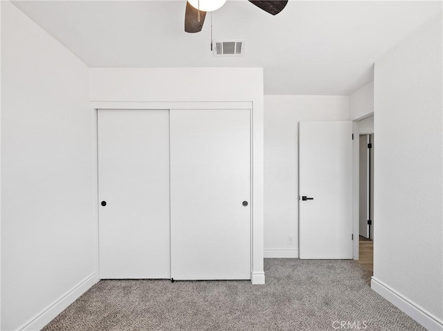 unfurnished bedroom featuring visible vents, carpet flooring, baseboards, and a closet