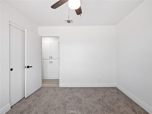 unfurnished bedroom featuring a closet, baseboards, carpet flooring, and visible vents