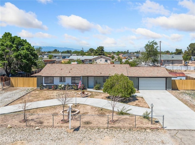 ranch-style house with a residential view, driveway, a fenced front yard, and a garage