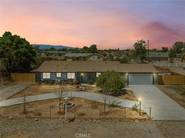 view of front of property with a residential view, fence private yard, driveway, and a garage
