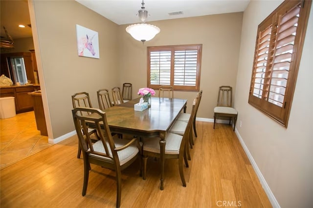 dining space featuring baseboards, visible vents, and light wood-type flooring