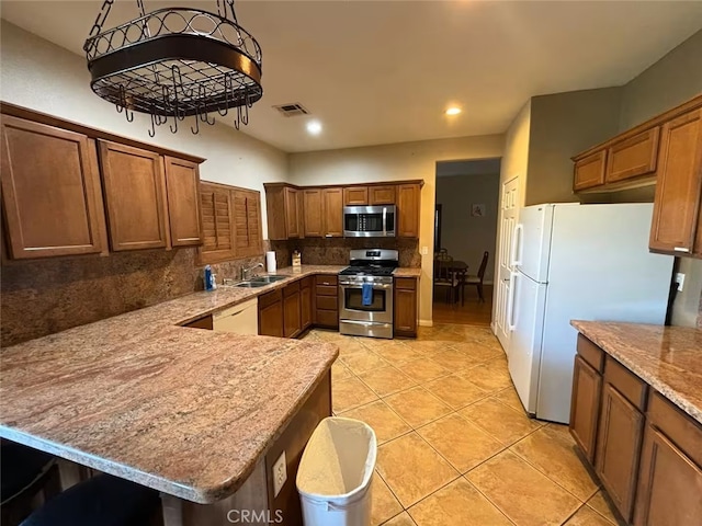 kitchen with stainless steel appliances, a peninsula, decorative backsplash, light tile patterned floors, and visible vents