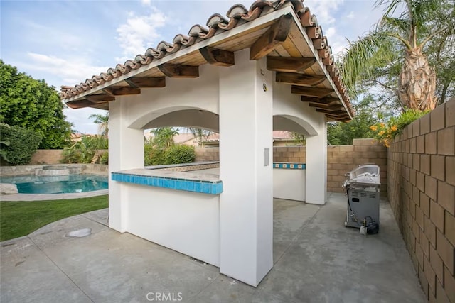 view of patio / terrace featuring a fenced backyard, a pool with connected hot tub, and area for grilling