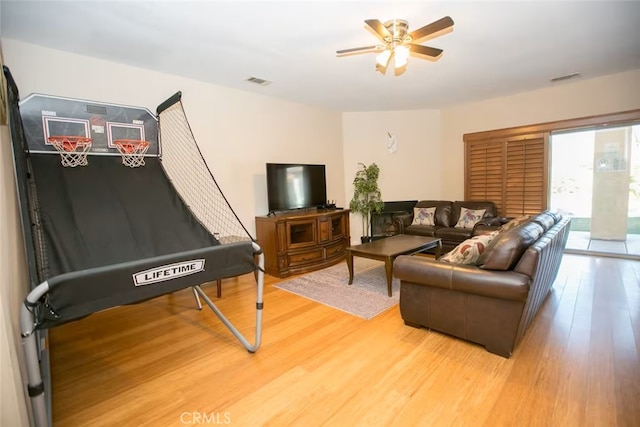 living area with a ceiling fan, visible vents, and light wood-style floors