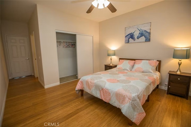 bedroom featuring baseboards, ceiling fan, a closet, and wood finished floors