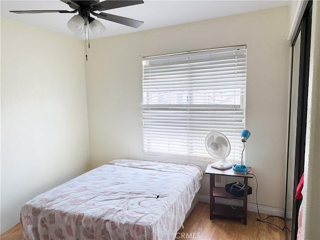 bedroom featuring baseboards, a ceiling fan, and wood finished floors