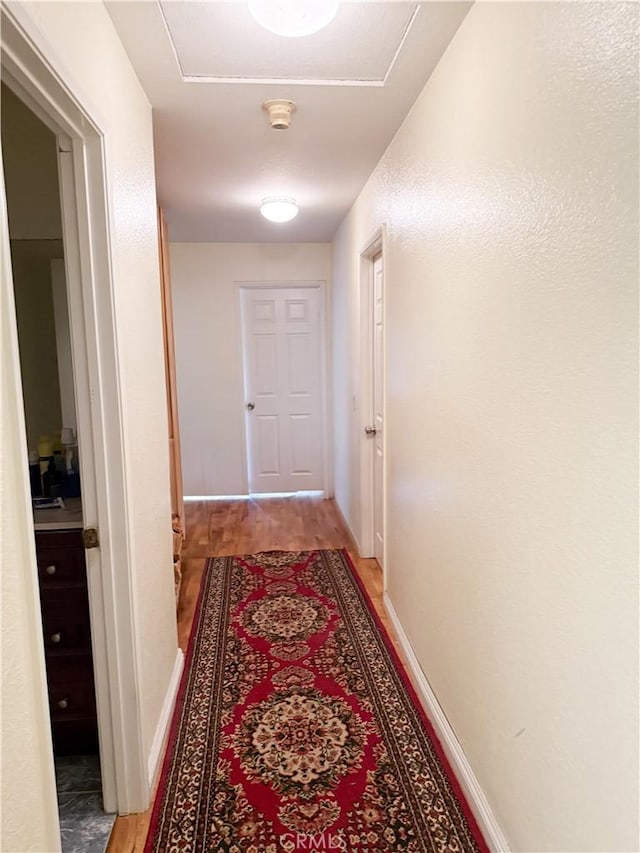 hall featuring baseboards and light wood finished floors