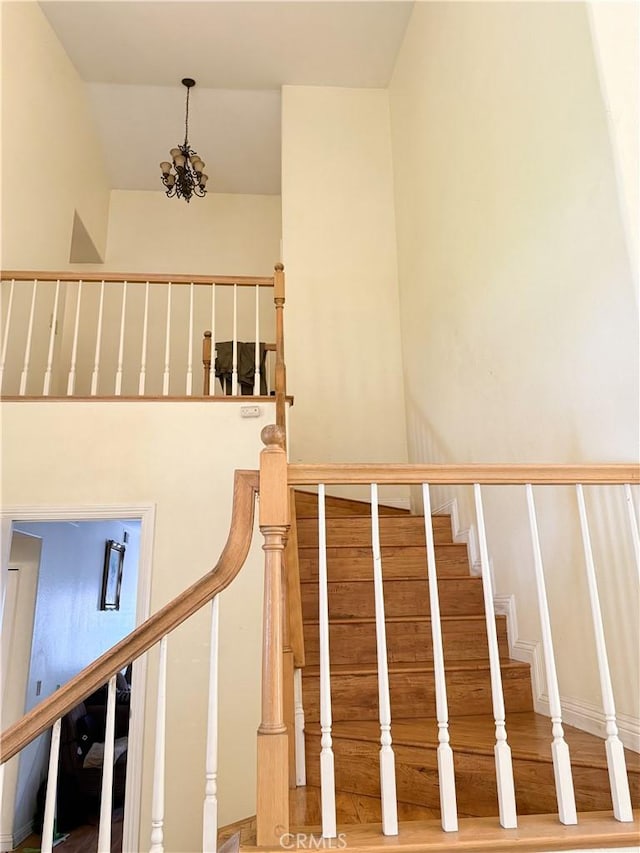 stairs featuring an inviting chandelier and vaulted ceiling